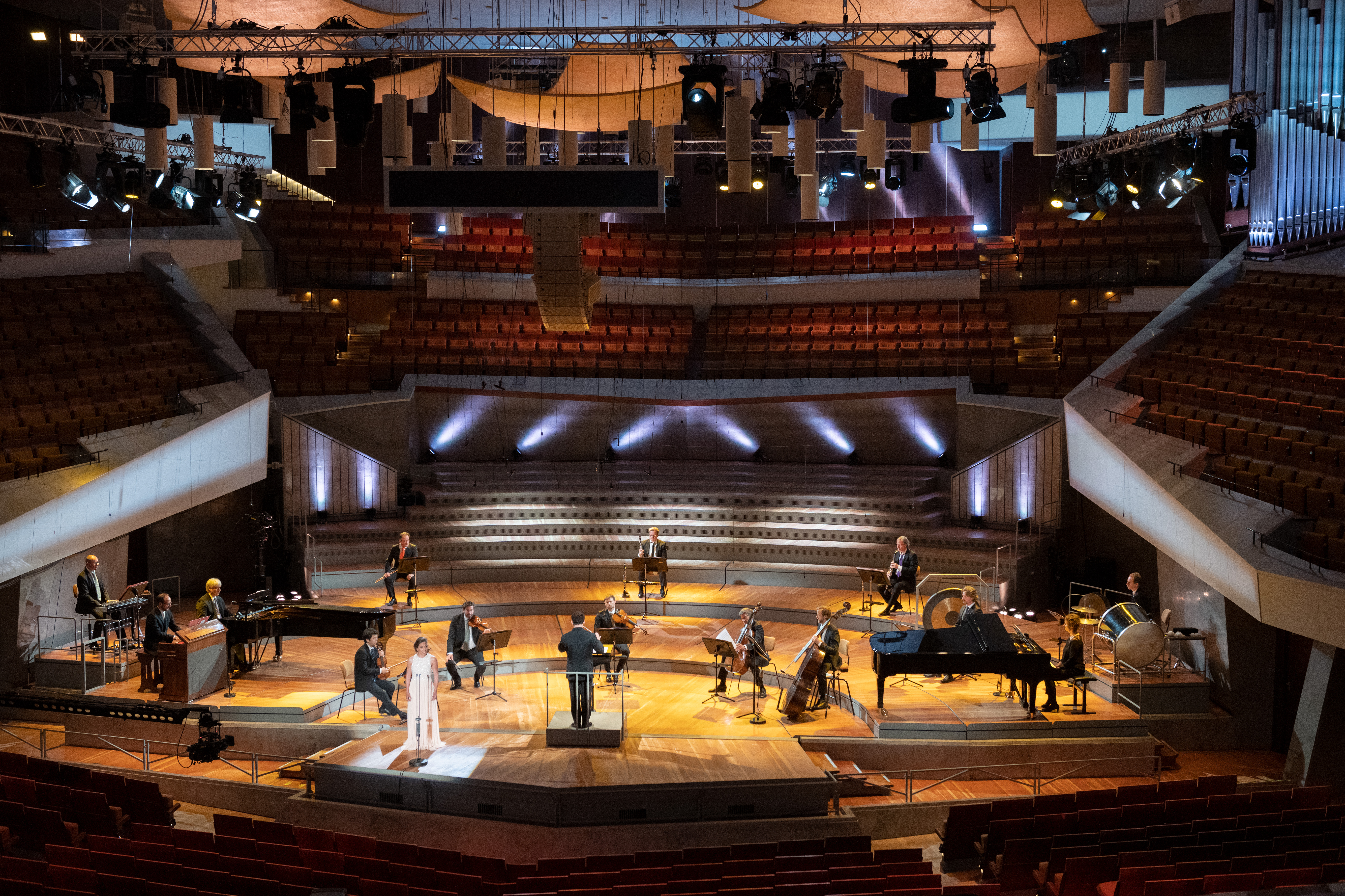 Die Bühne der Berliner Philharmonie: ein kleines Orchester sitzt über die Fläche der ganzen Bühne verteilt.