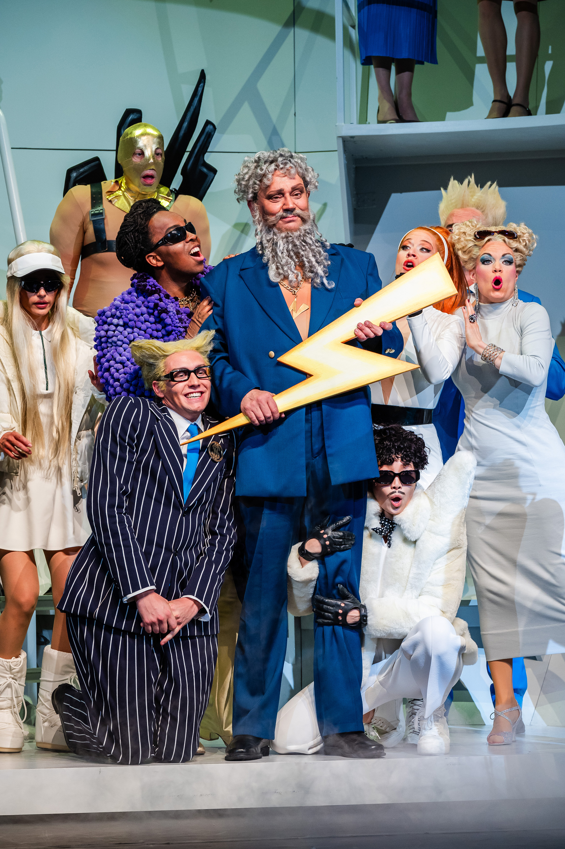 »Orpheus in der Unterwelt« von Jacques Offenbach an der Musikalischen Komödie Leipzig – Die Götter: Jupiter (Milko Milev, Mitte), Cupido (Da-yung Cho, unten rechts), Diana (Nora Lentner), Venus (Olivia Delauré, ganz rechts), Mars (Michael Raschle, oben mit Maske), Merkur (Sandro Hähnel, links unten), Bacchus (Kyle Fearon-Wilson, links neben Jupiter). © Kirsten Nijhof 