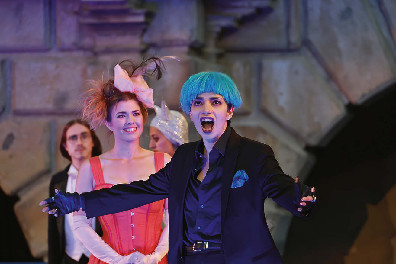 Chiara Ducomble als Orlofsky in schwarzem Anzug mit blauen Haaren.