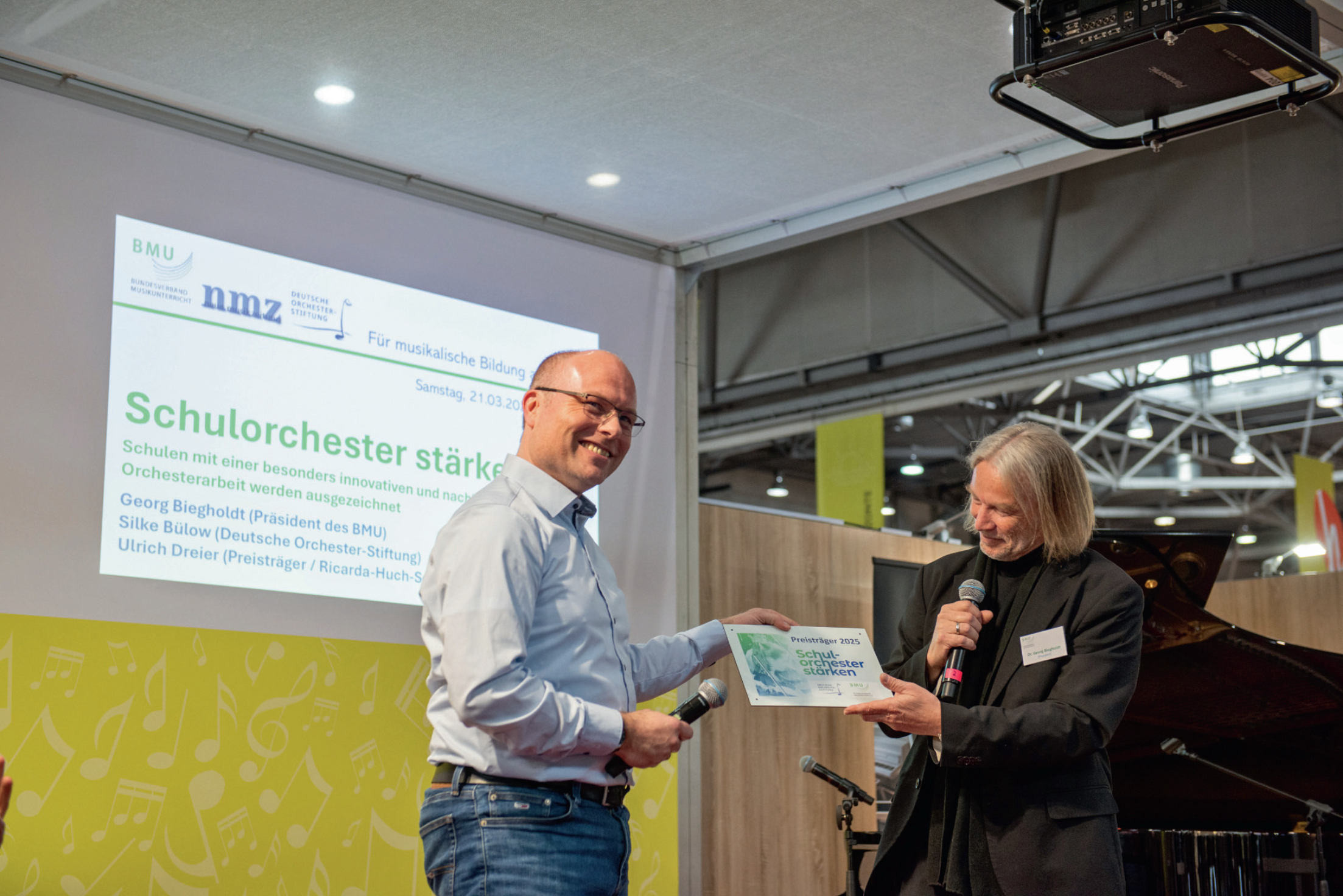 Ulrich Dreier von der Ricarda-Huch-Schule Hannover nimmt den BMU-Preis &bdquo;Schulorchester st&auml;rken&ldquo; aus der Hand von Georg Biegholdt entgegen. 