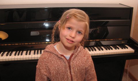 Julia (7 Jahre) an ihrem Klavier, Foto zur Veröffentlichung freigegeben. 