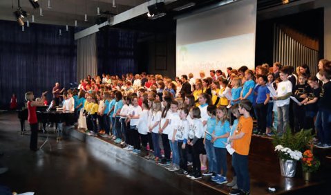 Ein Chor mit Schüler/-innen und Lehrkräften aus ganz Hessen singt unter Angela Assmann beim Festakt  zum 10. Geburtstag der Musikalischen Grundschule in Frankfurt a.M. Foto: Meuer/Archiv Musikalische Grundschule Hessen