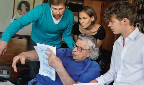 13 Theodorakis-Lieder, neu arrangiert: Der Komponist Sebastian Schwab (ganz rechts), der Pianist Markus Zugehör und die Sopranistin Johanna Krumin besuchten Mikis Theodorakis in Athen mit ihren Bearbeitungen. Foto: Jens Roetzsch