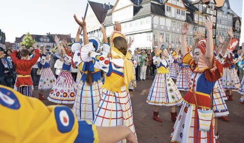 Tanzende in bunten Kleider-Trachten auf dem Marktplatz von Wolfenbüttel beim EUROTREFF