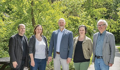 Die genannten Damen und Herren mittleren Alters stehen bei bestem Wetter im Grünen.