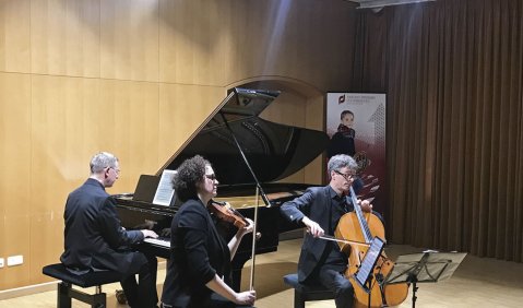 Ein Klaviertrio aus zwei Männern (Klavier und Cello) und einer Violinistin.