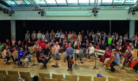 Ein Orchester aus Musiklehrer*innen probt zusammen mit Julia Fischer und Johannes X. Schachtner.