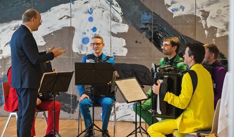 Akkordeon-Quartett in bunten Anzügen: Rot, Blau, Grün, Violett und Gelb.