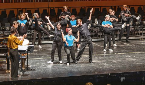 Ein choreographierende Chor in Schwarz und Blau.