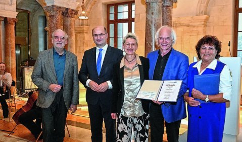 Die genannten in Blau, Grau, Schwat und Weiß in einer altehrwürdig marmormen Halle.