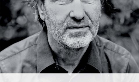 Buch Cover mit in Schwarz-Weiß, mit einem dreitagebärtigen Mann mit längeren kurzen Haaren.