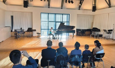 Ein junge spielt in einem geräumigen Kammermusiksaal vor Publikum am Flügel.