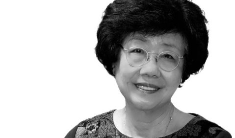 Eine Koreanerin mittleren Alters, mit kurzen und etwas buschigen Haaren, Brille und freundlichem Lächeln.