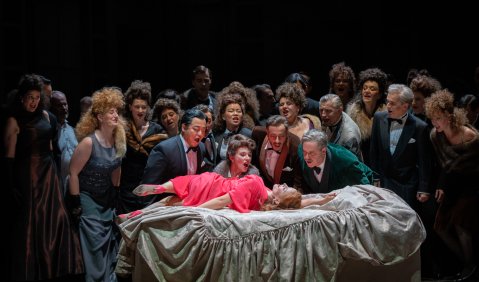 Liegend: Sarah Vautour (Violetta Valéry), darüber Seungwoon Lee (Dottore Grenvil), Dorothee Bienert (Flora Bervoix), Irakli Atanelishvili (Marchese d’Obigny), Kammersänger Paul Brady (Barone Douphol), mit Opernchor und Statisterie.  Foto: © Stephan Walzl