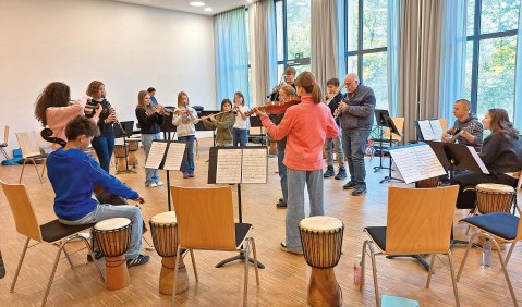 Ein großes Ensemble in einem großen Seminar-Probenraum.