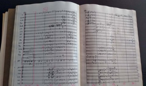 Eine handschriftliche Partitur in einem aufgeschlagenen Buch gebunden.