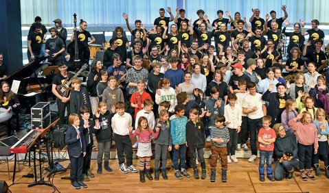 Eine große Menge junger Musiker:innen unterschiedlicher Altersgruppen.