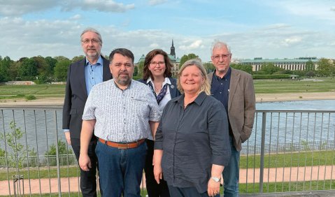 Fünf Menschen am Elbe-Ufer in Dresden.