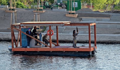 Li-chin Li spielt ihre Sheng auf einem Boot auf der Spree vor dem Ufer des Radialsystems. Foto: Stefan Stahnke
