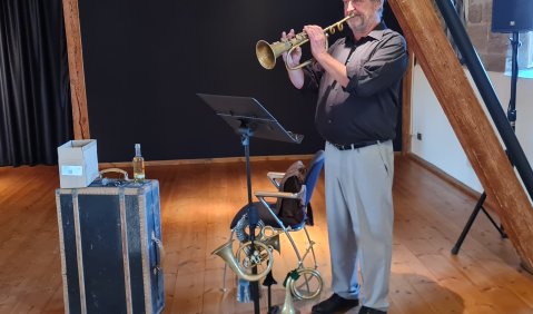 Willi Budde hatte zur Ausstellungseröffnung mehrere unterschiedliche Hörner mitgebracht – sie stehen gleichermaßen für den Einsatz als Signalhörner im Krieg und als Instrumente der Stadtmusiker und Orchester, die Orte einer bürgerlichen Musikkultur.