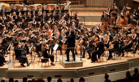 Ein junges Studierendenorchester spielt mit viel Engagement geleitet im großen Saal der Berliner Philharmonie.