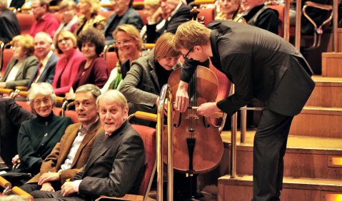 Musikerinnen und Musiker verlassen die Bühne, mischen sich unters Publikum reichen ihre kostbaren Instrumente an ZuhörerInnen weiter. Foto: Joerg Hejkal