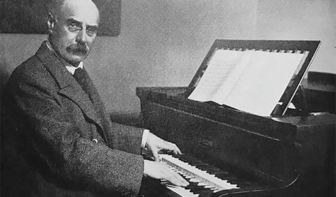 Schwarzweißbild des Erfinders an seinem Instrument. Moór hat eine Glatze und einen Schnäuzer, er trägt einen festen dunklen, aber nicht schwarzen Anzug. Das Foto ist schwarzweiß.