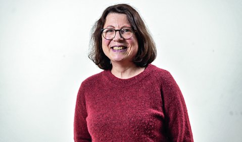 Portrait von Katrin Steinbach, einer Frau mit knapp schulterlangen braunen Haaren, Brille und rotem Pullover.