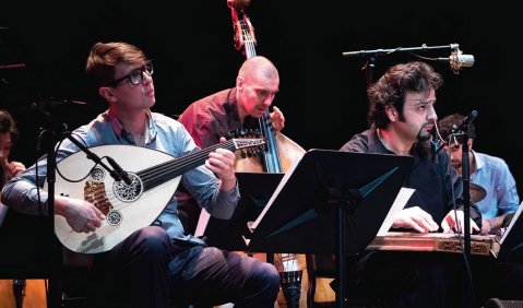 Titelbild  Vier Mitglieder des 22-köpfigen Ensembles Diwan der Kontinente:  Matthias Kurth (Oud), Ralf Schwarz (Kontrabass), Bassem Alkhouri (Kanun) und Ketan Bhatti (Schlagzeug) beim Jazzfest Berlin (Bericht auf Seite 23). Foto: Petra Basche