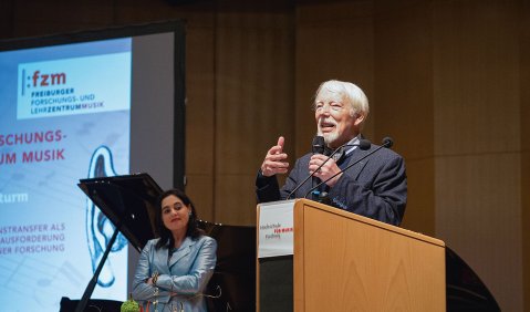 Jan Assmann bei seinem Vortrag. Im Hintergrund Claudia Spahn, als Prorektorin Forschung/Internationales der Hochschule für Musik Freiburg für das FZM und die Tagung verantwortlich. Foto: Juan Martin Koch
