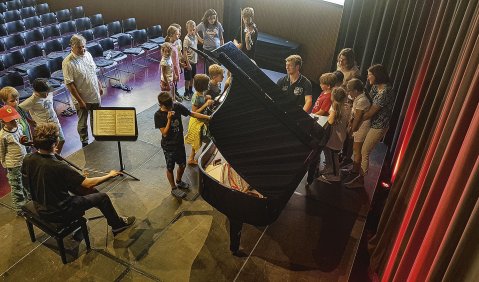 Constantin Schiffner (Klavier), der tschechische Cellist Jakub William Gráf und der polnische Geiger Wiktor Dziedzic stellten Musikschulkindern vor ihrem Konzert in Kufstein ihre Instrumente vor. Foto: Manuela Matran