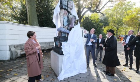 Oberbürgermeister Stephan Keller (M.) und Markus Lüpertz enthüllen am Ratinger Tor das Schumann-Denkmal «A Danse À Deux». Foto: Landeshauptstadt Düsseldorf/Michael Gstettenbauer