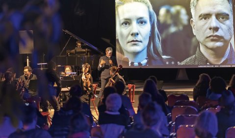 Im Saal des Seilerbahn Kunst Kultur Vereins in Frankfurt stimmte das Publikum über die Handlung des interaktiven Videooper-Computergames „Kairosis“ von Moritz Eggert und Moritz Schneidewendt ab. Unser Foto zeigt das Broken Frames Syndicate mit Moritz Eggert bei der Einführung – auf dem Bildschirm die Schauspielerin Elena Fellisch und Dirigent Lautaro Mura Fuentealba. Foto: Paul Pape Im Saal des Seilerbahn Kunst Kultur Vereins in Frankfurt stimmte das Publikum über die Handlung des interaktiven Videooper-Computergames „Kairosis“ von Moritz Eggert und Moritz Schneidewendt ab. Unser Foto zeigt das Broken Frames Syndicate mit Moritz Eggert bei der Einführung – auf dem Bildschirm die Schauspielerin Elena Fellisch und Dirigent Lautaro Mura Fuentealba. Foto: Paul Pape