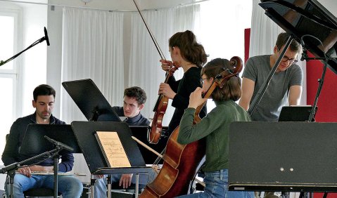 Mehrere Instrumentalist:innen proben zusammen.