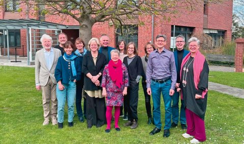 Die Gruppe steht draußen zum Gruppenfoto zusammen.