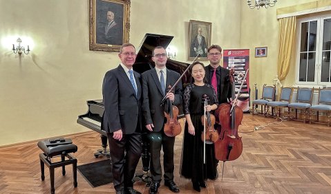 Das Klavierquartett vor dem Flügel in einem altehrwürdigen Saal.