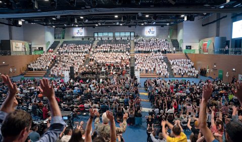 Eine große Sporthalle voll mit Menschen verschiedener Altersstufen