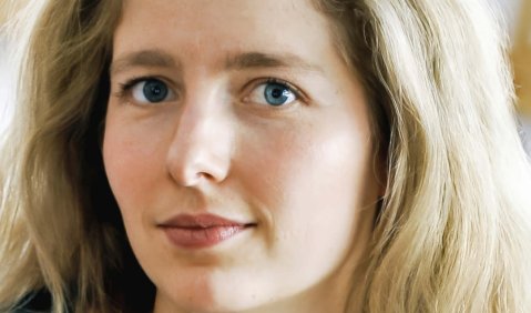 Eine blonde Frau jüngeren mittleren Alters.