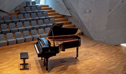 Ein Flügel in einem Saal mit stark verwinkeltem Sichtbeton.