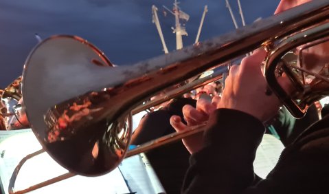 Ein Posaunist bei der abendlichen Serenade – im Hintergrund Schiffskräne. © Ralf-Thomas Lindner Ein Posaunist bei der abendlichen Serenade – im Hintergrund Schiffskräne. © Ralf-Thomas Lindner